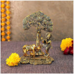 Krishna playing flute under a tree with holy cow feeding calf with milk