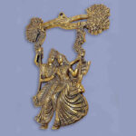 Metal made wall hanging item showing radha krishna on a jhula tied on tree