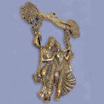 Metal made wall hanging item showing radha krishna on a jhula tied on tree